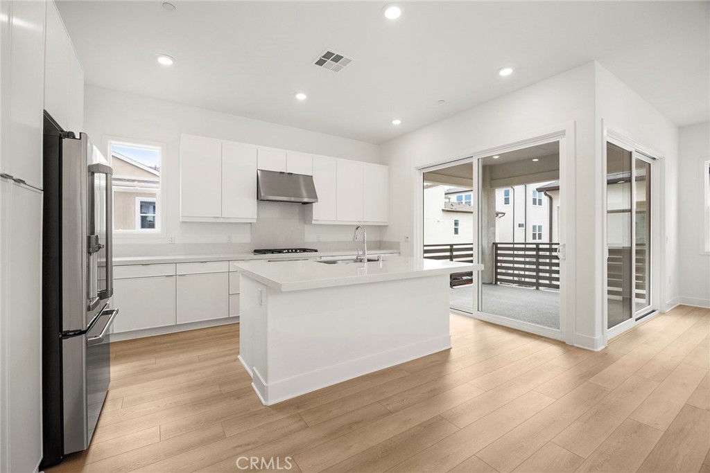 124 Tiffin Irvine, CA 92618 - Photo 9 of 26 a kitchen with white cabinets and refrigerator