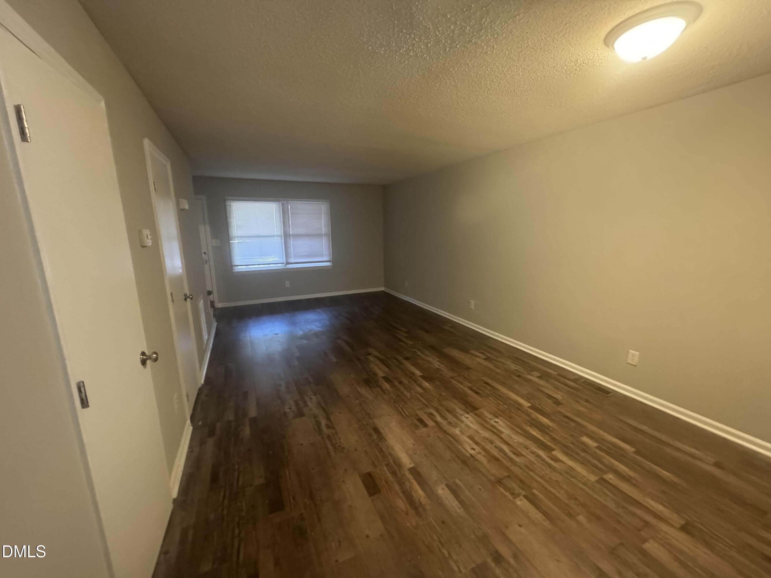 5105 Vann Street, Unit C Raleigh, NC 27606 - Photo 3 of 11 an empty room with wooden floor and windows
