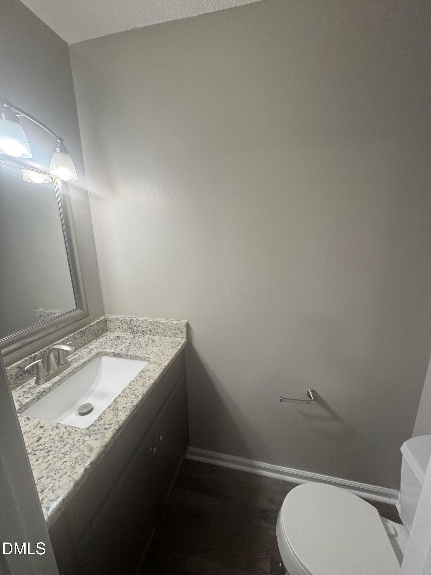 5105 Vann Street, Unit C Raleigh, NC 27606 - Photo 4 of 11 a bathroom with a granite countertop sink vanity mirror and toilet