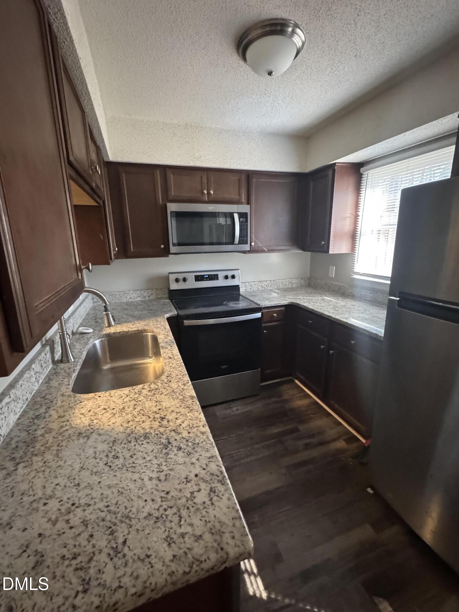 5105 Vann Street, Unit C Raleigh, NC 27606 - Photo 5 of 11 a kitchen with stainless steel appliances granite countertop a sink stove and microwave