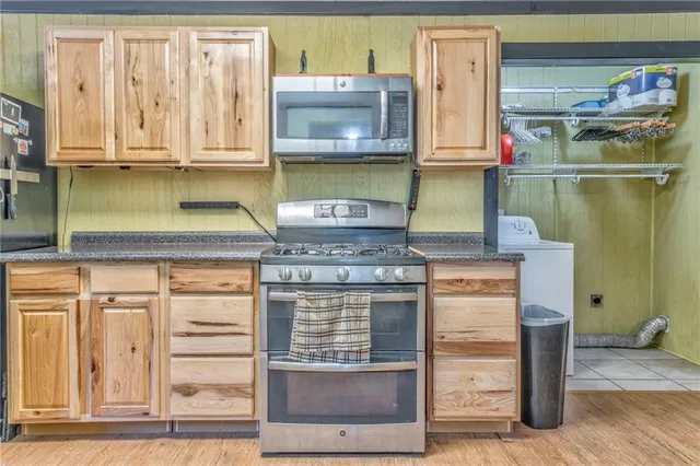 a kitchen with stainless steel appliances granite countertop lots of counter top space and wooden floor