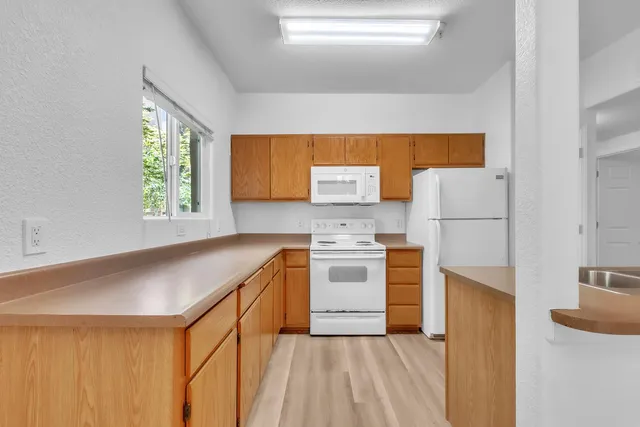 a kitchen with stainless steel appliances granite countertop a sink window and cabinets