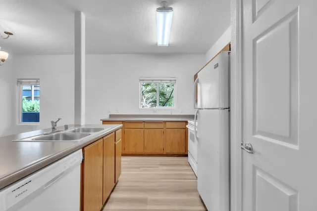 a view of a hallway with wooden floor and a bathroom