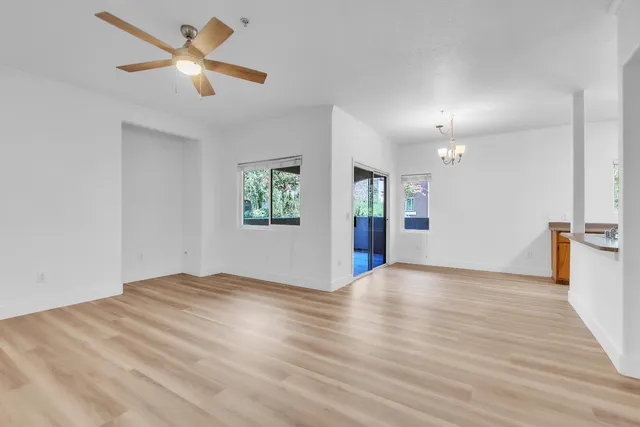 a view of an empty room with window and wooden floor