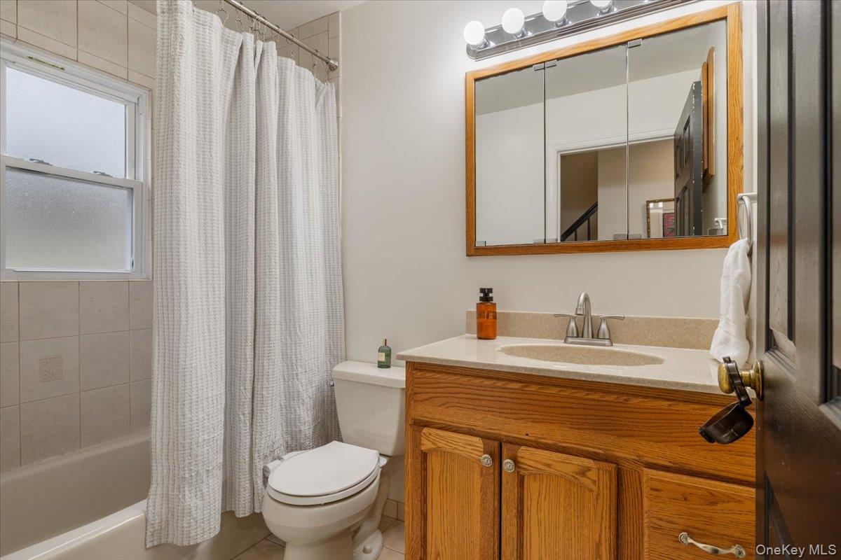 223 Bread And Cheese Hollow Road Northport, NY 11768 - Photo 14 of 32 a bathroom with a sink a toilet and a mirror