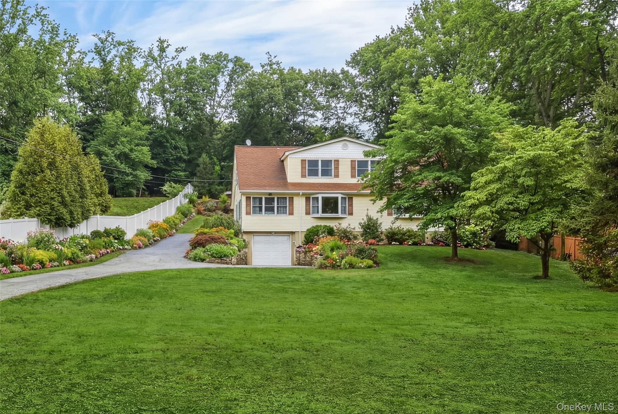 223 Bread And Cheese Hollow Road Northport, NY 11768 - Photo 2 of 32 a front view of a house with a yard table and chairs