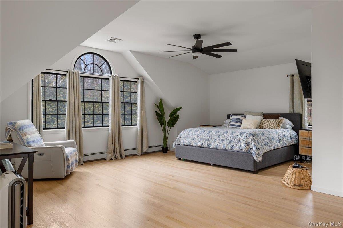 223 Bread And Cheese Hollow Road Northport, NY 11768 - Photo 22 of 32 a bedroom with a bed and wooden floor