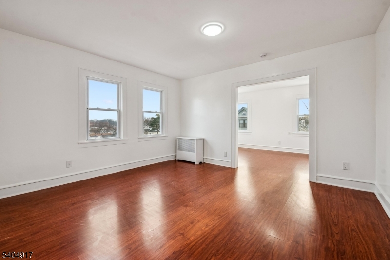 167 Silver Avenue, Unit 3 Hillside, NJ 07205 - Photo 11 of 15 a view of an empty room with wooden floor and a window