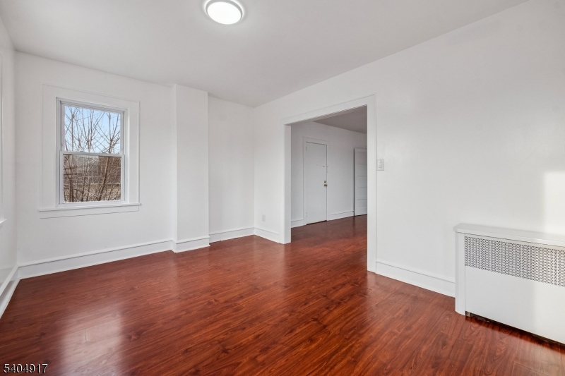 167 Silver Avenue, Unit 3 Hillside, NJ 07205 - Photo 12 of 15 an empty room with wooden floor and windows