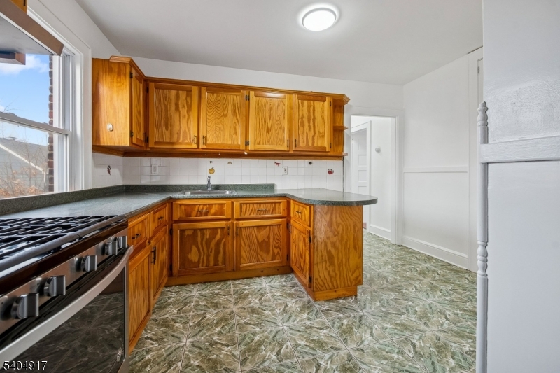 167 Silver Avenue, Unit 3 Hillside, NJ 07205 - Photo 3 of 15 a kitchen with granite countertop a sink and a stove