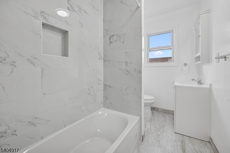 167 Silver Avenue, Unit 3 Hillside, NJ 07205 - Photo 4 of 15 a bathroom with a sink a toilet and shower