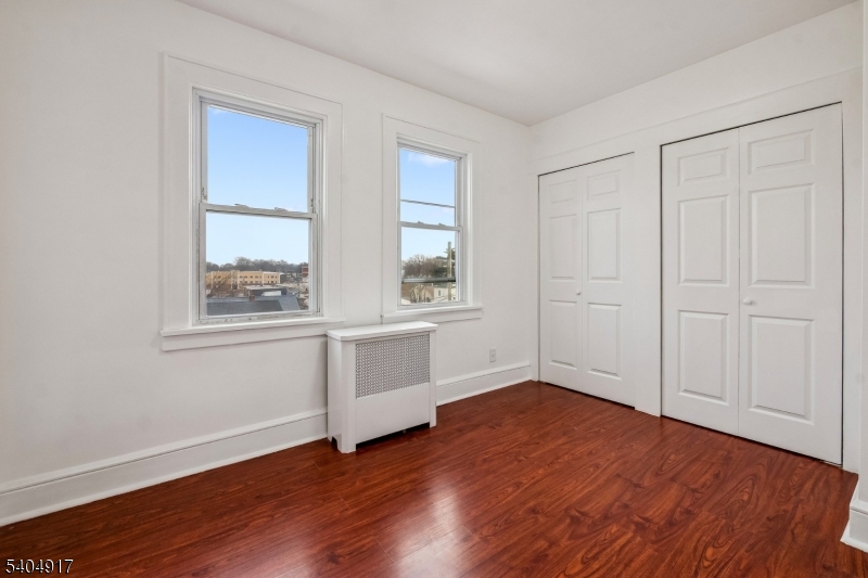 167 Silver Avenue, Unit 3 Hillside, NJ 07205 - Photo 7 of 15 an empty room with wooden floor and windows