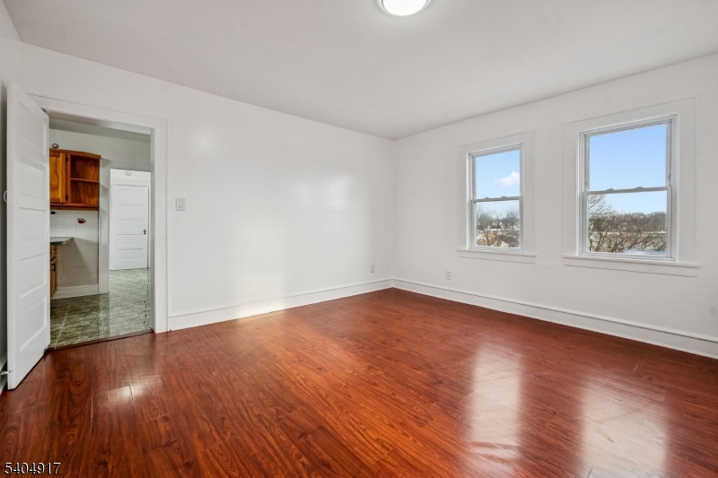 167 Silver Avenue, Unit 3 Hillside, NJ 07205 - Photo 9 of 15 a view of an empty room with wooden floor and a window