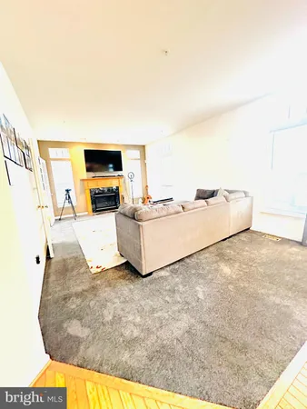 a living room with couches and kitchen view