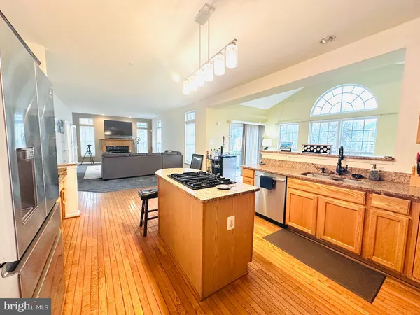 a large kitchen with stainless steel appliances granite countertop a lot of counter space and wooden floors