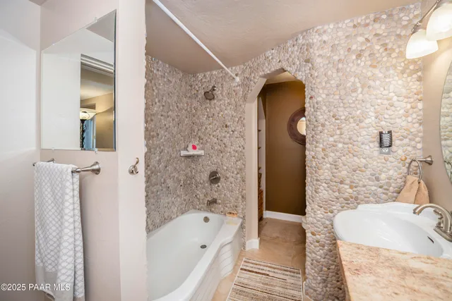 a bathroom with a tub sink and mirror