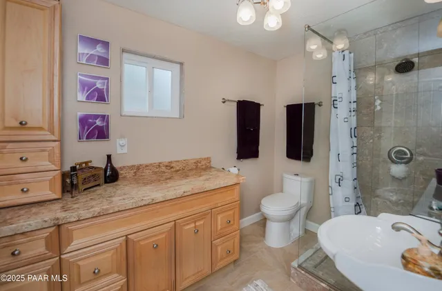a bathroom with a granite countertop toilet sink and mirror
