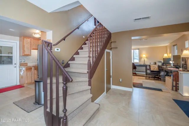 a view of a hallway view with staircase and kitchen view