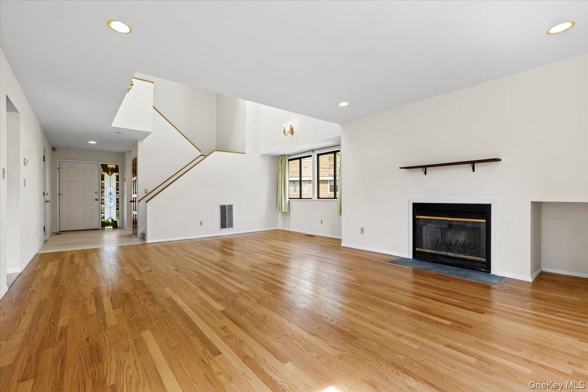 88 Farm Lake Cres Road Chappaqua, NY 10514 - Photo 7 of 22 a view of empty room with wooden floor and fireplace