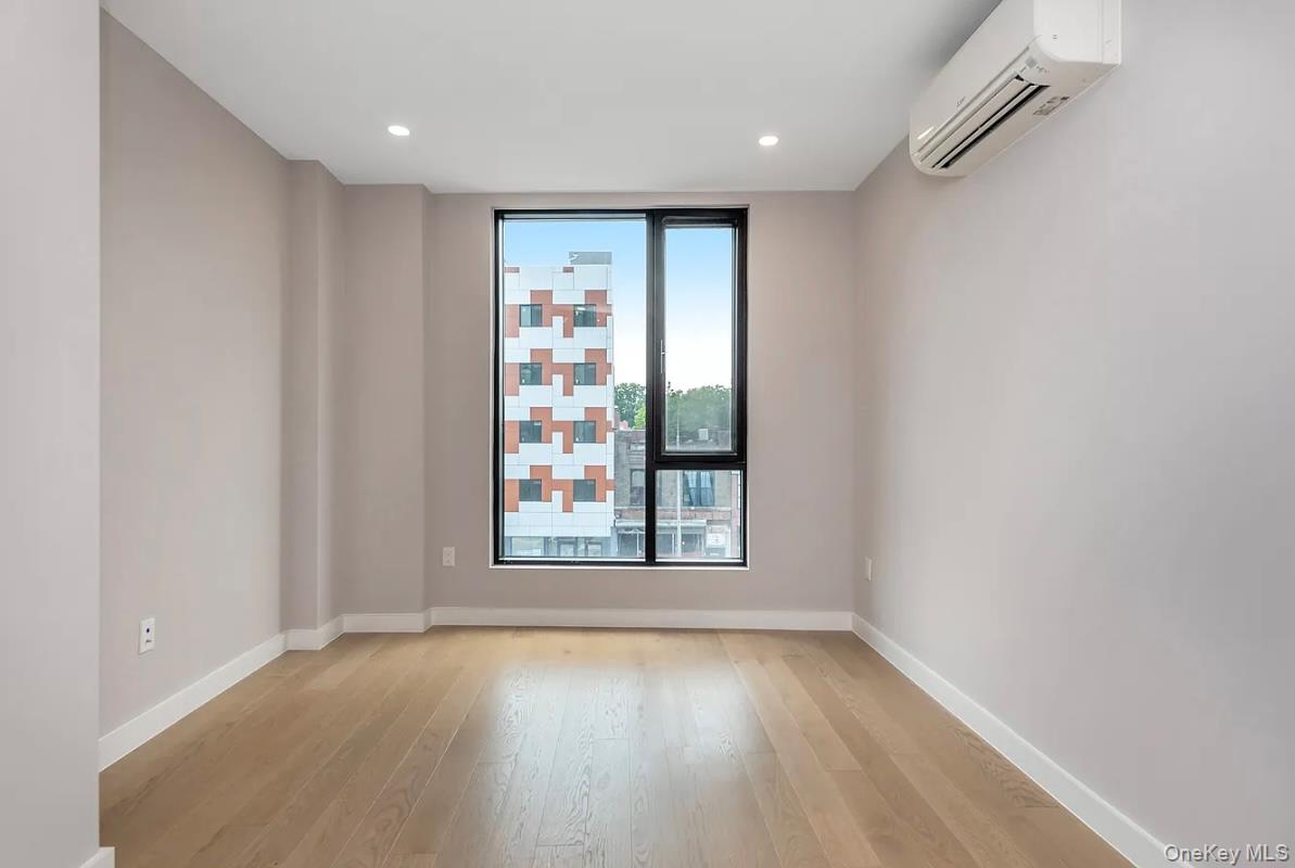 32-58 105th Street, Unit 4A Queens, NY 11369 - Photo 2 of 8 an empty room with wooden floor and windows