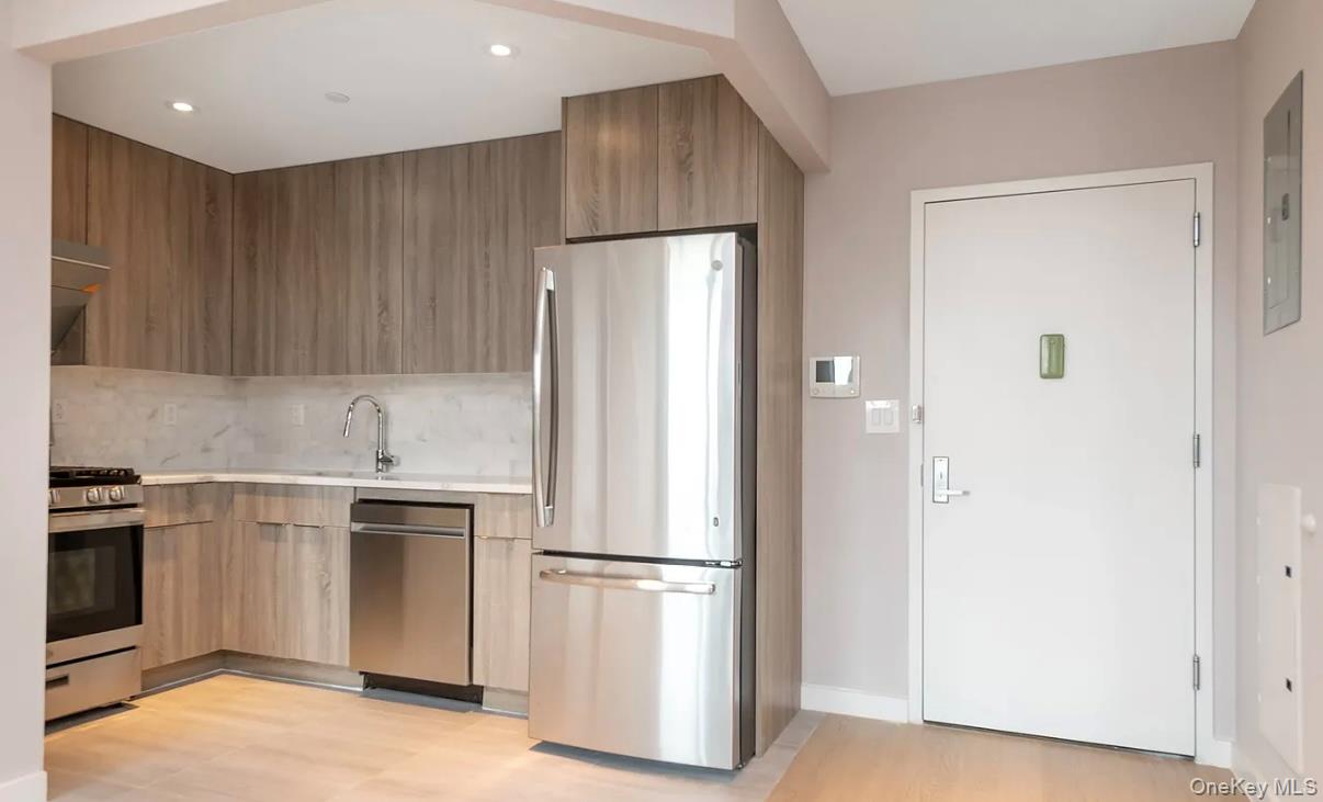32-58 105th Street, Unit 4A Queens, NY 11369 - Photo 3 of 8 a kitchen with stainless steel appliances a refrigerator and a stove top oven