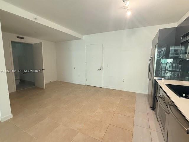 31 Southeast 6th Street, Unit 1804 Miami, FL 33131 - Photo 5 of 15 a kitchen with granite countertop a sink and a stove top oven