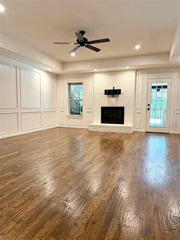 a view of a livingroom with wooden floor and a ceiling fan