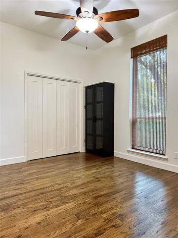 a view of an empty room with a window and a ceiling fan