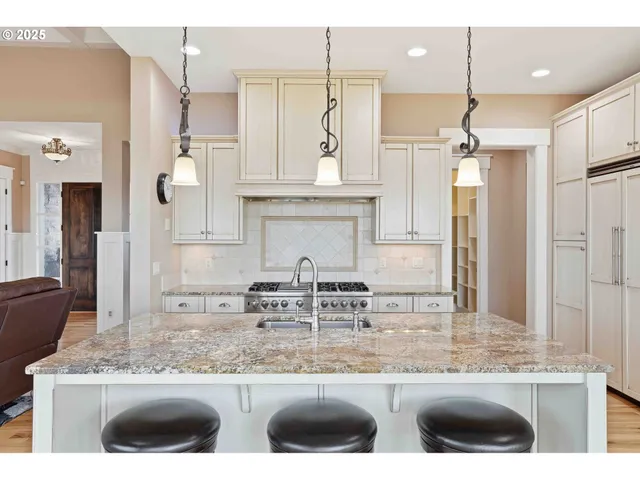 a kitchen with stainless steel appliances granite countertop a sink and a refrigerator