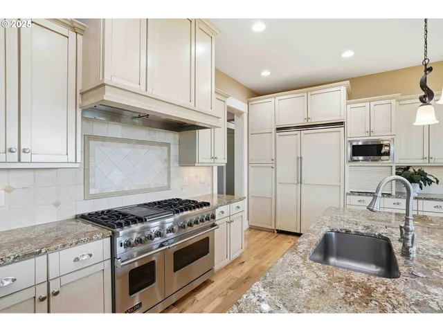 a kitchen with granite countertop a sink stove and refrigerator