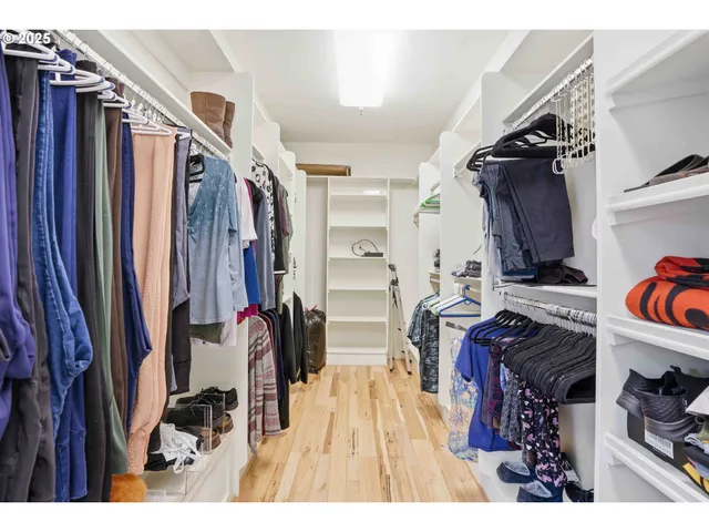 a view of walk in closet with clothes and shoes