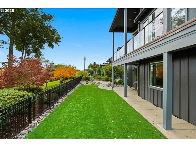 a backyard of a house with table and chairs floor to ceiling window and wooden floor