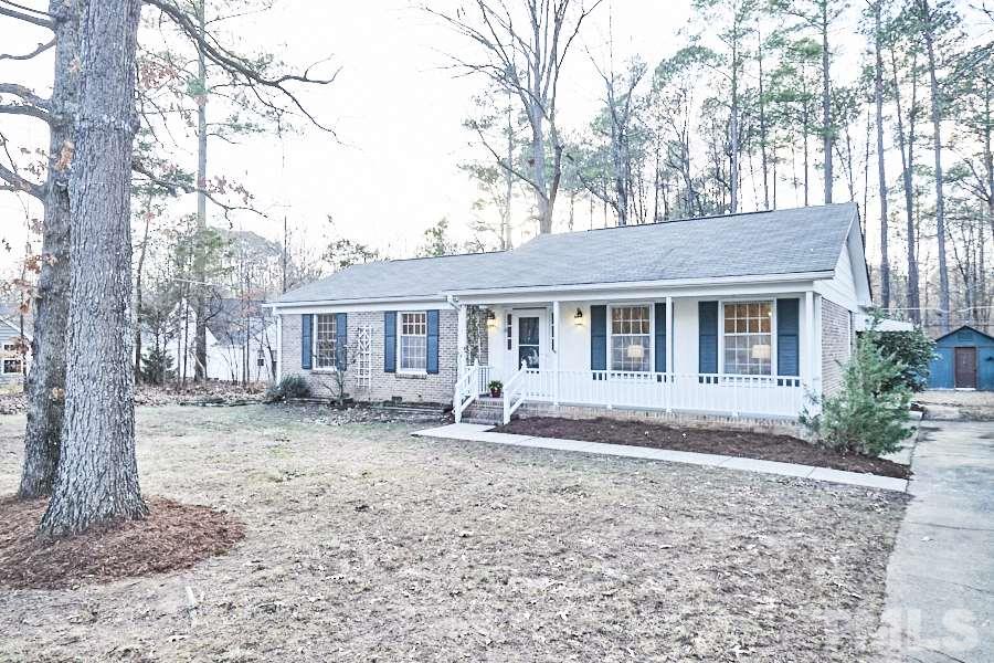 5908 Newhall Road Durham, NC 27713 - Photo 8 of 23 a front view of a house with a garden and trees