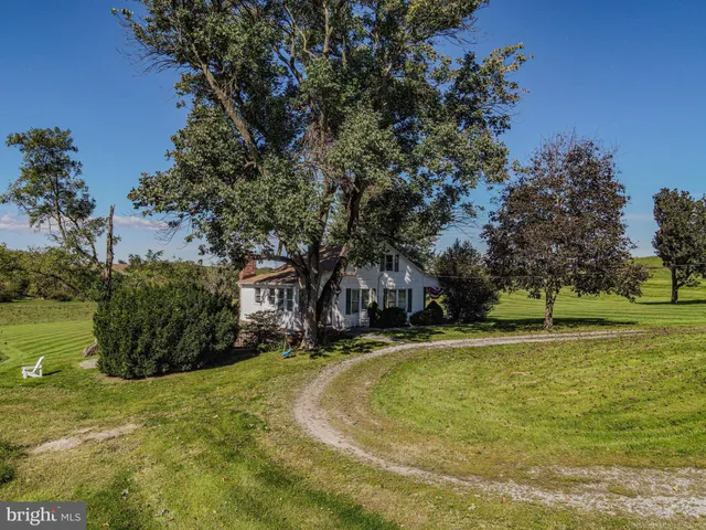 a view of a swimming pool with lawn chairs and a big yard
