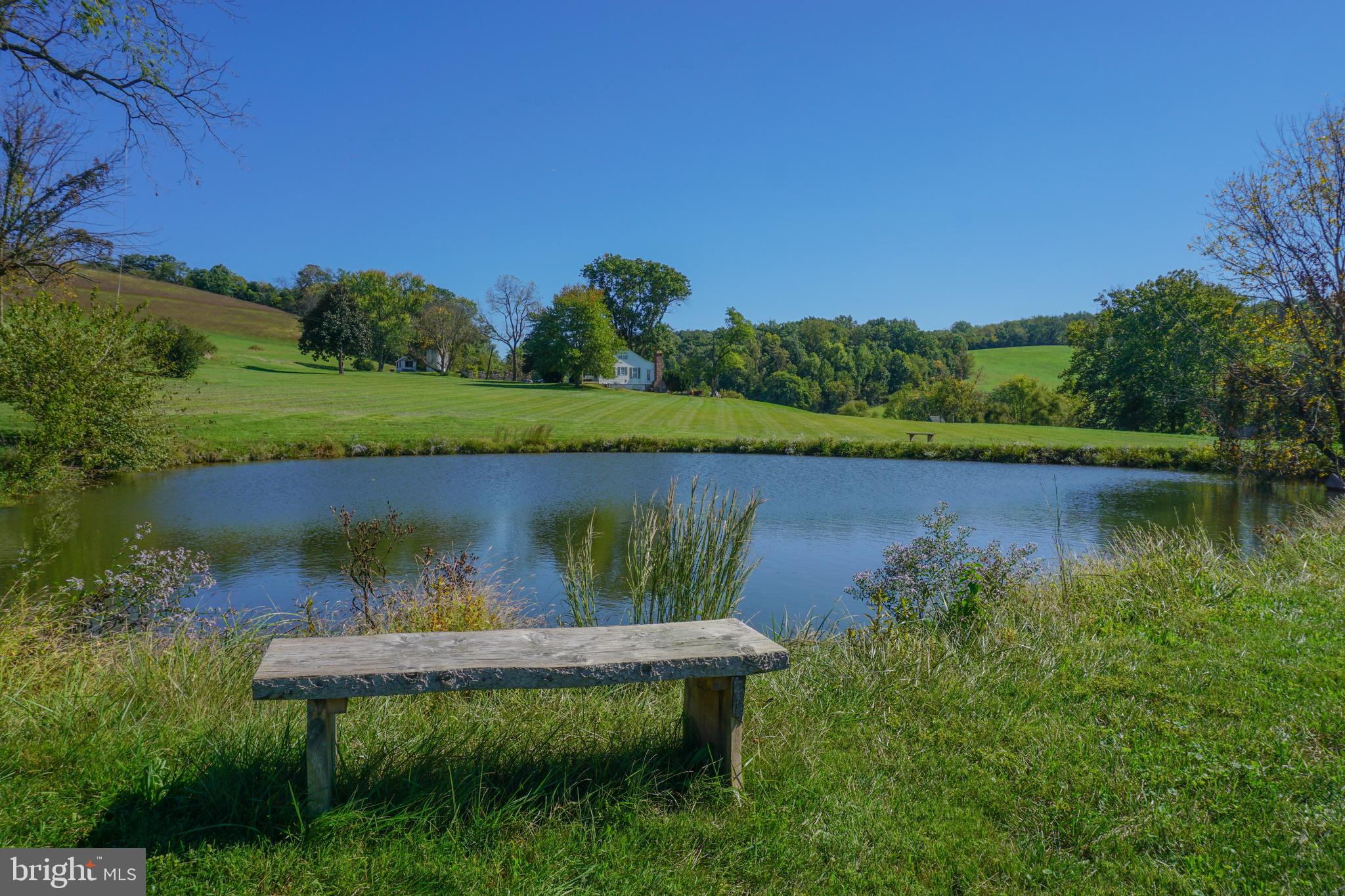 4205 Sams Creek Road New Windsor, MD 21776 - Photo 70 of 103 a view of a lake with a yard and outdoor seating