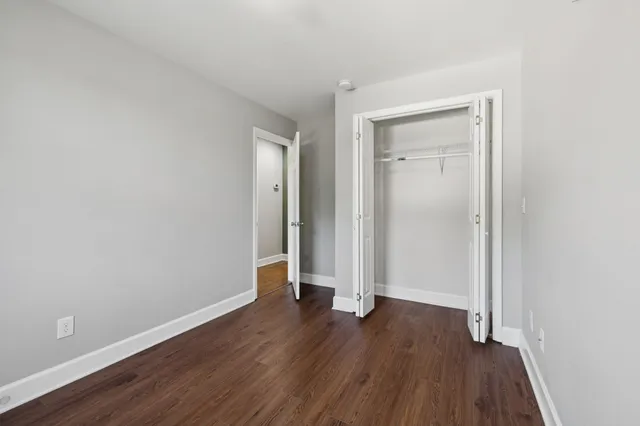 an empty room with wooden floor and closet