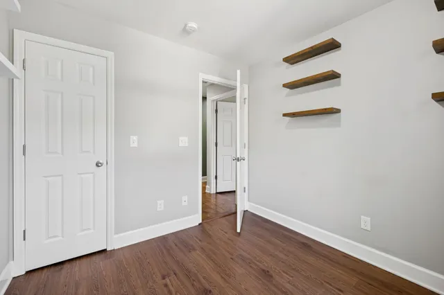 an empty room with wooden floor and closet