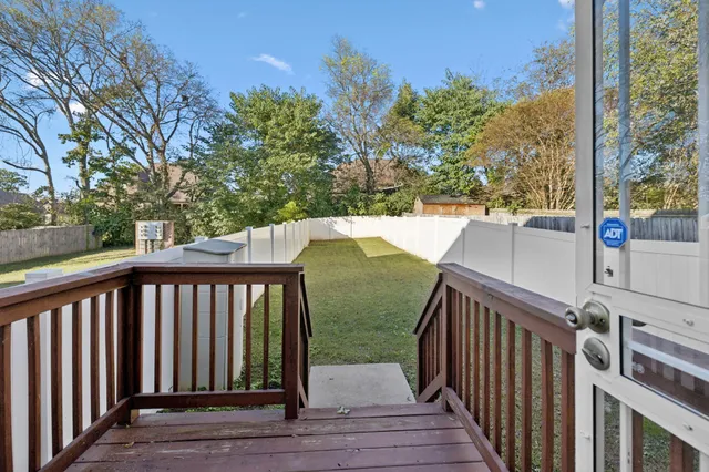 a view of a balcony with wooden floor and fence