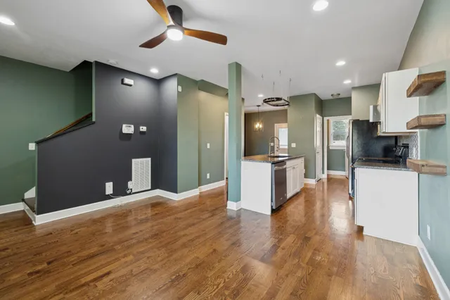 a view of a kitchen with stainless steel appliances kitchen island wooden floors and granite counter tops