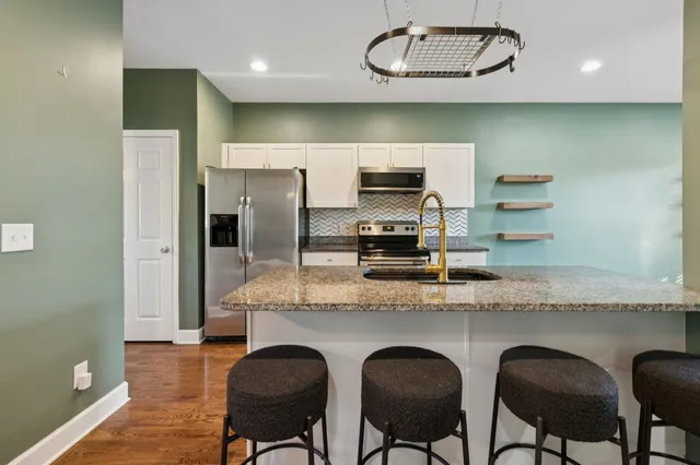 a kitchen with cabinets and chairs