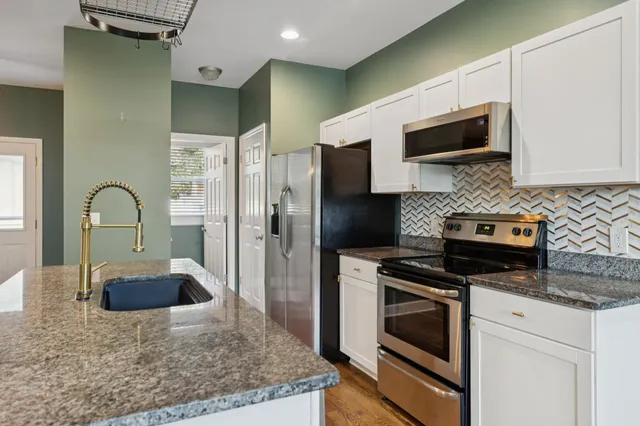 a kitchen with kitchen island a sink stainless steel appliances and cabinets