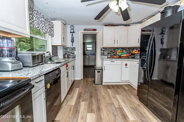 a kitchen with stainless steel appliances granite countertop a refrigerator a stove a sink dishwasher and a stove with wooden floor