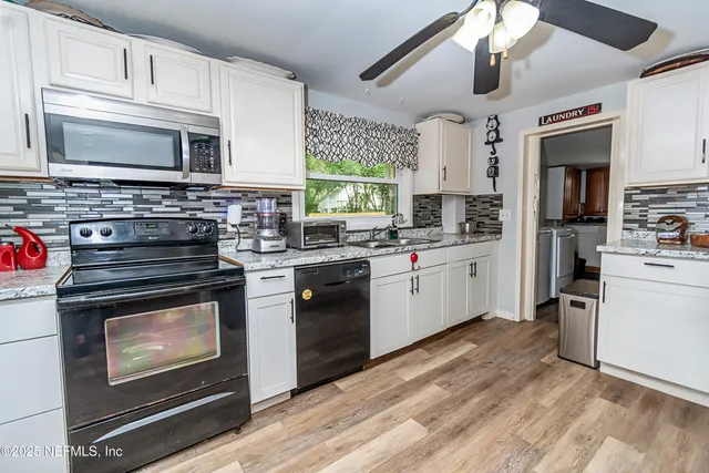 a kitchen with stainless steel appliances a stove sink microwave and cabinets