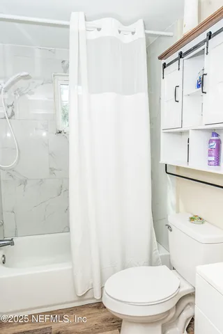 a white toilet sitting next to a bath tub and a shower