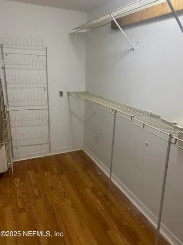 a view of walk in closet with empty racks