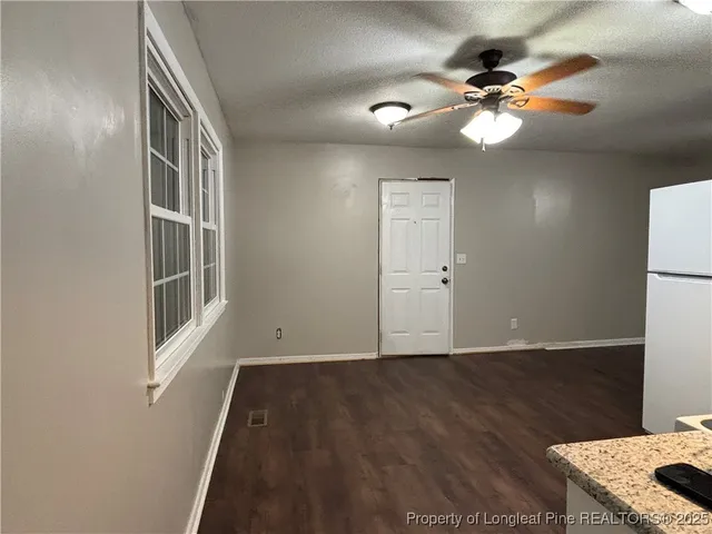 a view of an empty room with a chandelier fan