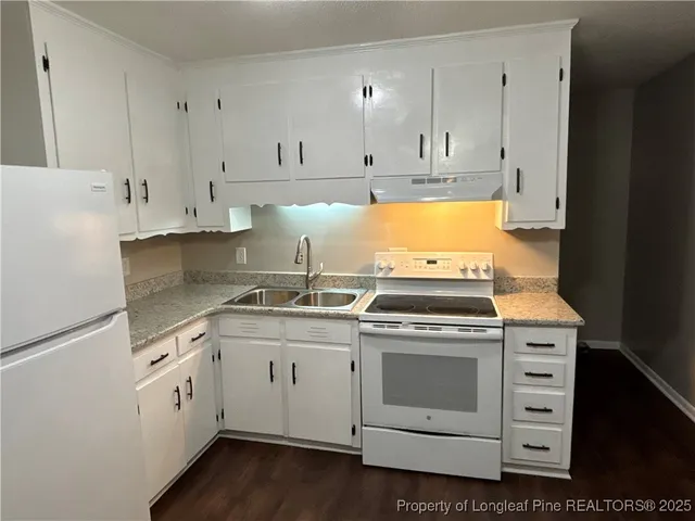 a kitchen with cabinets appliances and a wooden floor