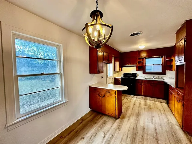 a kitchen with stainless steel appliances granite countertop a stove and a wooden floors