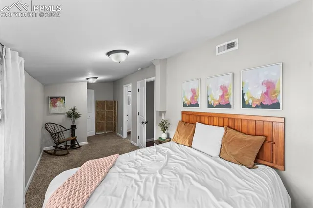 a bedroom with a bed and a painting on the wall