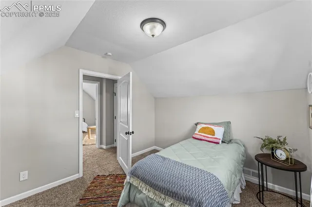 a bedroom with a bed and a wooden floor